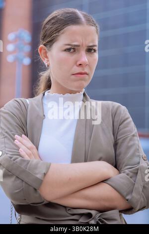 Giovane donna d'affari sicura di sé seria con le braccia incrociate che guardano la telecamera. Foto Stock