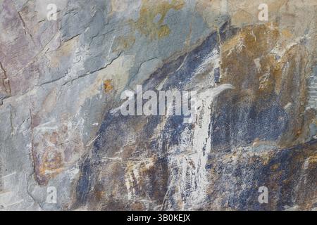 Primo piano della superficie in pietra ruvida con motivi di colore terroso multicolore Foto Stock