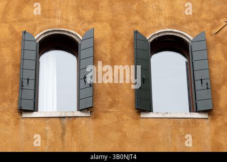 Due finestre ad arco con otturatori verdi Foto Stock