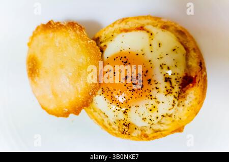 Uova nel nido, cotte in una pagnotta di pane. Uova camiciate. Foto Stock