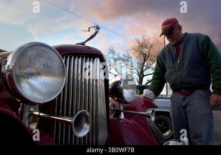 26 gennaio 2001 - Turlock, California, Stati Uniti - Dan Norton mette uno straccio sul parafango anteriore sinistro di questa replica Cadillac del 1932. Norton sta controllando l'auto per il proprietario Mike Girnder. Secondo Norton, il macinacaffè vuole 35.000 dollari. Auto e ricambi di tutte le marche e modelli continuavano a girare il venerdì pomeriggio fino all'autunno notturno. Sabato sarà sicuramente pieno di appassionati di auto. (Immagine di credito: © Bart Ah You 012601/Modesto Bee/ZUMAPRESS.com) Foto Stock