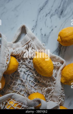 Limoni in un cestino della spesa netto Foto Stock