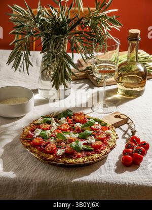 pizza in crosta di zucchine appena sfornata con pomodori ciliegini, asparagi, foglie di spinaci e ricotta. Foto Stock