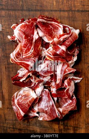 Prosciutto spagnolo affettato finemente Jamon Iberico paleta su tagliere in legno. Vista dall'alto, primo piano Foto Stock