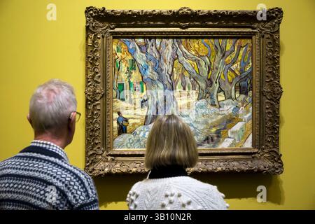 Persone che ammirano i grandi alberi di aeroplano (Road Menders a Saint-Rémy) di van Gogh alla mostra Poets and Lovers alla National Gallery. Foto Stock