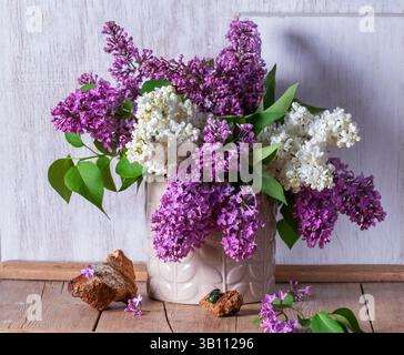 Bouquet di lillate multicolore, trucioli di legno e insetti su sfondo chiaro. Foto Stock