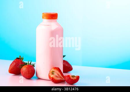 Frullato di latte alla fragola in vaso usa e getta eco e frutti di bosco freschi. Frullato, bevanda vitaminica o yogurt in bottiglia di plastica su sfondo colorato. Foto Stock
