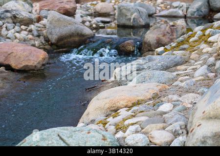 acqua blu che si getta sulle rocce Foto Stock