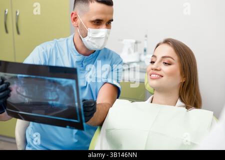 Dentista a raggi X, dentista sorridente, che mostra dentista a raggi X, medico maschile che esamina, dentista mostra, centro dentista medico, consulenza clinica dentale Foto Stock