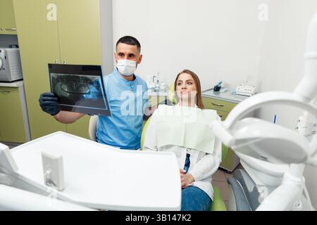 Radiografia panoramica, consultazione dentale, clinica odontoiatrica, ispezione dentale, dentista dice al paziente, trattamento dei denti, paziente sorridente Foto Stock