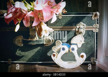 Valigia nera vintage polverosa con fiori all'interno Foto Stock