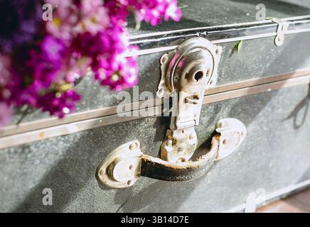 Valigia nera vintage polverosa con fiori all'interno Foto Stock