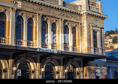 TRIESTE, ITALIA - 17 DICEMBRE 2024: Facciata architettonica di Trieste centrale, la principale stazione ferroviaria di Trieste, Italia, in mostra la sua storica desi Foto Stock