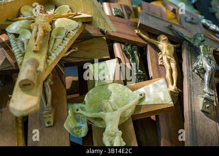 Una collezione di crocifissi con figure di Gesù in legno e metallo esposta presso uno stand del mercato delle pulci a Berlino, Germania. Foto Stock