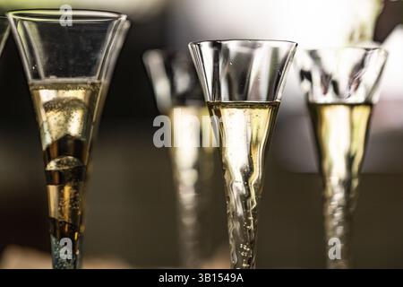 Primo piano di calici pieni di champagne o flute di champagne contro la luce Foto Stock
