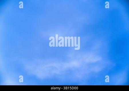 Il cielo azzurro e limpido, pieno di morbide nuvole, crea un'atmosfera serena durante il giorno. I colori vivaci evocano un senso di calma e tranquillità Foto Stock