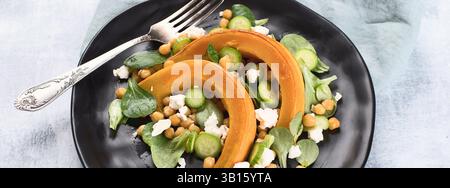 Insalata di zucca arrosto con feta e ceci su sfondo grigio. Vista dall'alto. Foto Stock