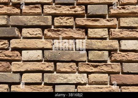 Pareti in mattoni beige caldi alla luce del sole Foto Stock