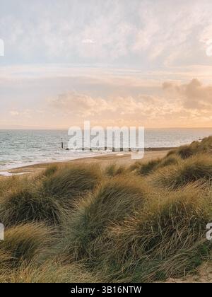 Hengistbury Head Beach al tramonto - Golden Hour Coastal Landscape nel Dorset, Inghilterra Foto Stock