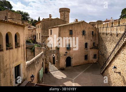 Una vista pittoresca di un villaggio storico con edifici in pietra, strade strette e una torre sullo sfondo. L'architettura riflette un fascino rustico Foto Stock