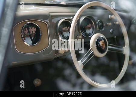 Vista ravvicinata del cruscotto e del volante di una Porsche classica, che mostra il suo design vintage e la sua maestria artigianale. Foto Stock