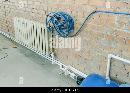 Radiatore di riscaldamento in ghisa su un nuovo impianto di riscaldamento Foto Stock