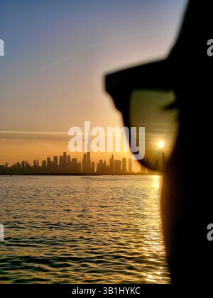 Splendido tramonto sul Dubai Creek, cielo caldo e skyline con sfondo Burj Khalifa attraverso occhiali da sole Foto Stock