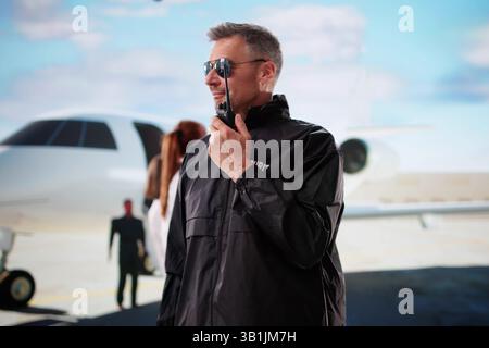 Guardia di sicurezza che protegge Un VIP vicino a Un jet privato all'aeroporto. , Agente Foto Stock