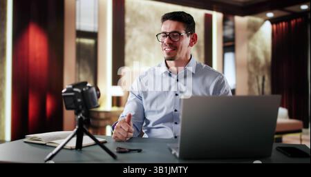 Travel Influencer nella camera d'hotel. Happy Man in streaming sulla fotocamera Foto Stock