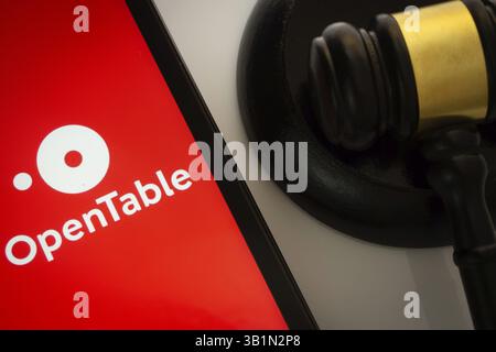 Dacca, Bangladesh - 17 marzo 2025: Primo piano di uno schermo per iPad che mostra l'app open table accanto al martelletto di un giudice Foto Stock