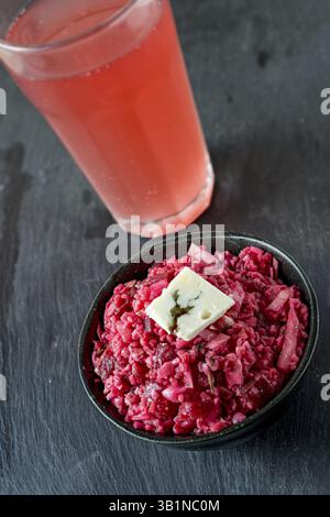 Insalata di barbabietole con mele e formaggio Roquefort. Federweisser rosso sullo sfondo Foto Stock