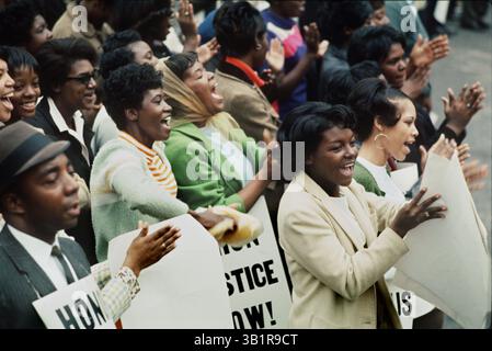 8 aprile 1968 - Memphis, TN, Stati Uniti - i membri del pubblico tifanno durante i discorsi al City Hall plaza 8 aprile 1968. La vedova del dottor Martin Luther King Jr., Coretta Scott King, e tre dei quattro figli della coppia hanno condotto una marcia commemorativa attraverso il centro di Memphis quel lunedì. Il reverendo Ralph Abernathy e molti altri noti diritti civili e leader sindacali erano tra circa 19.000 persone provenienti da tutta la nazione che parteciparono. La signora King e altri hanno parlato con la massa di lutto da una piattaforma al City Hall plaza. "Quelli di voi che credono in ciò che Martin Luther King rappresentava, vi sfiderei Foto Stock
