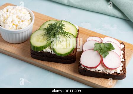 Panini a vista preparati al momento con cetrioli e ravanelli serviti con formaggio fresco Foto Stock