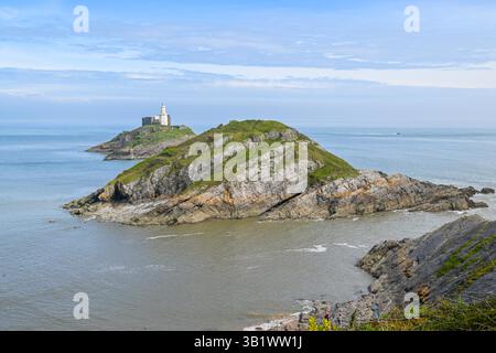 Mumbles, Galles, Regno Unito. 26 aprile 2025. Meteo nel Regno Unito. Vista generale verso il faro di Mumbles a Mumbles vicino a Swansea, in Galles, in un pomeriggio di sole caldo e nebuloso. Crediti fotografici: Graham Hunt/Alamy Live News Foto Stock
