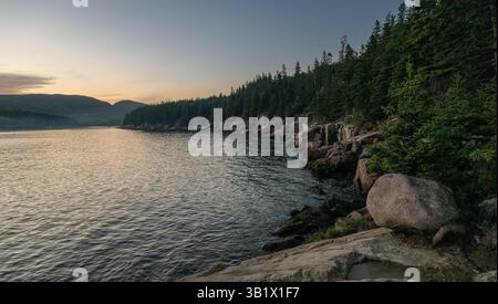 La luce dell'ora d'oro riflette al largo della costa del Parco Nazionale dell'Acadia Foto Stock