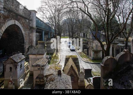 Cimitero di Montmartre, ufficialmente Cimetière du Nord, con il viadotto di Rue Caulaincourt di passaggio, a Parigi, Francia Foto Stock