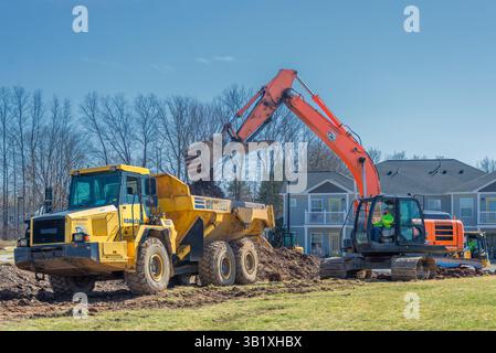 Dumper Komatsu HM300 e escavatore Hitachi 210LC per la preparazione del cantiere. Aeroporto di Ontario County. Farmington, New York Foto Stock