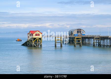 Mumbles, Galles, Regno Unito. 26 aprile 2025. Vista generale del Mumbles Pier a Mumbles vicino a Swansea, in Galles, che mostra le vecchie e nuove stazioni di salvataggio. I proprietari della Amusement Equipment Co's hanno dovuto chiudere una vasta sezione del molo vittoriano al pubblico nel 2023 a causa di problemi di sicurezza ed è in cattivo stato di riparazione e ha bisogno di milioni di sterline per ripristinarlo in condizioni di sicurezza. Anche la stazione di salvataggio RNLI sull'estremità del molo ha dovuto chiudere e trasferirsi a causa della mancanza di accesso sicuro e di problemi strutturali, con la scialuppa di salvataggio ora ormeggiata al di fuori della fine del molo. Crediti fotografici: Graham Hunt/Alamy Live Foto Stock