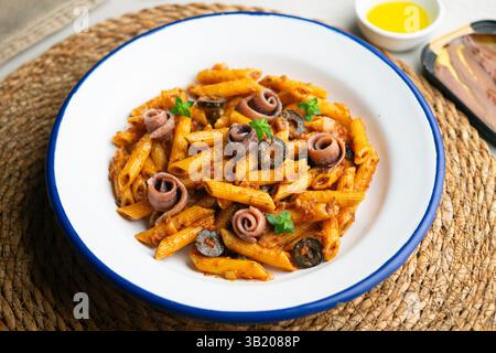 Pasta italiana maccheroni penne alla siciliana con acciughe e pomodoro Foto Stock