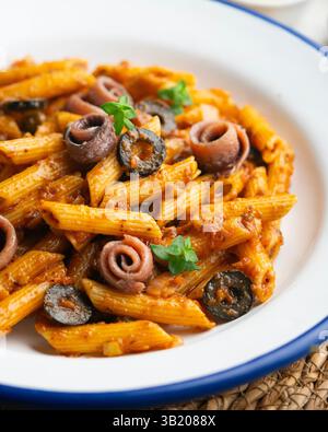 Pasta italiana maccheroni penne alla siciliana con acciughe e pomodoro Foto Stock