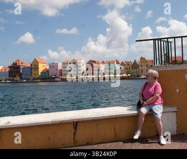 28 gennaio 2010 - Willemstad, Curacao, Antille olandesi - Un turista riposa sul lungomare nella zona di Otrabana di Willemstad. Attraverso la baia di Sant'Anna, le case di mercanti coloniali color pastello costeggiano Handelskade lungo il lungomare di Punda di Willemstad. Questi edifici ben conservati in stile olandese sui canali, che risalgono 100 a oltre 250 anni fa, hanno inserito Willemstad nella lista dei siti patrimonio dell'umanità dell'UNESCO. Cura ao è la più grande e popolosa delle tre isole ABC (Aruba, Bonaire e cura ao) delle piccole Antille. (Immagine di credito: © Arnold Drapkin/ZUMAPRESS.com) Foto Stock