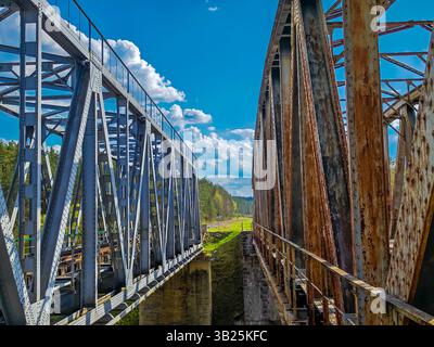 Abbandonate e oltre a strutture di ponti ferroviari in metallo di nuova costruzione. Vecchio ponte ferroviario in metallo in Lituania, chiamato Santakos gelezinkelio tiltas Foto Stock