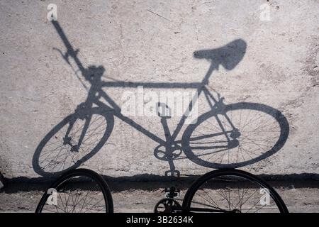 Ombra della bicicletta sul muro di cemento. Stile di vita sano, zero anidride carbonica Foto Stock