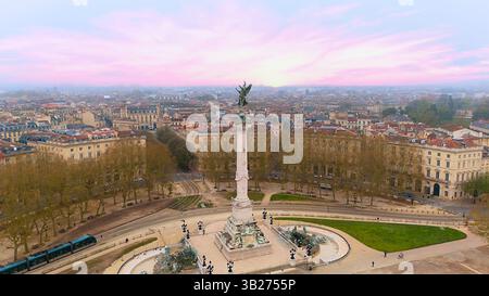 Vista aerea del Monumento dei Girondins a Bordeaux Francia 04.27.2025 con vivaci nuvole rosa e edifici storici e parco circostanti Foto Stock