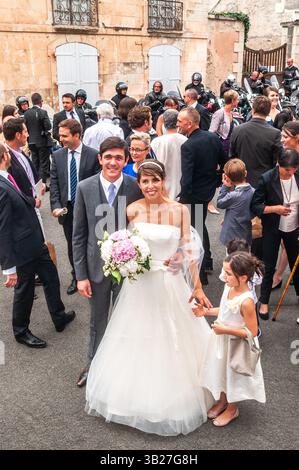 Coppia di sposi e festa di nozze dopo la cerimonia civile legale davanti alla chiesa per la seconda cerimonia - Preuilly-sur-Claise, Indre-et-Loire (37), Francia. Foto Stock