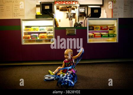 KAINAZ AMARIA | Times . PT 311107 AMAR pasmovies 1 di 2 (08/27/2009 Port Richey) . Ella dover, 17 mesi, suona con una serie di biglietti di fronte all'ambasciata 6 sale in concessione, mentre i suoi genitori Jason dover, 32 anni, e Chanel Casteel, 31 anni, si sforzano di preparare il posto per il prossimo fine settimana. La coppia ha aperto il teatro sabato 22 agosto scorso, ma secondo Chanel, "questa è la nostra prima vera apertura del fine settimana, non abbiamo pubblicizzato molto prima". I clienti stanno caricando i film di seconda esecuzione. L'Embassy 6 si trova sulla US 9510 Hwy 19 a Port Richey. [KAINAZ AMARIA, Times] (Cre Foto Stock