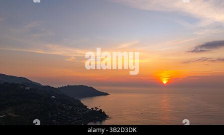 Una vista aerea mozzafiato di Kata Beach a Phuket, Thailandia, catturata durante il tramonto. L'immagine mostra la costa, le piccole isole, il lussureggiante hil verde Foto Stock
