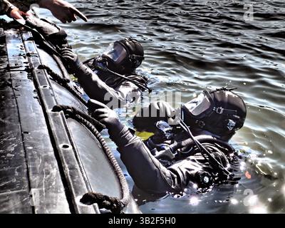 15 marzo 2014 - Virginia Beach, Virginia, Stati Uniti d'America - i subacquei della U.S. Navy ricevono istruzioni dal supervisore delle immersioni prima delle immersioni in acqua fredda con muta asciutta il 15 marzo 2014 presso la Joint Expeditionary base Little Creek, Virginia (immagine di credito: © PO1 Lance Fairchild/Planet Pix via ZUMA Wire) Foto Stock