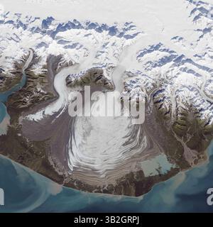 30 aprile 2015 - Groenlandia TERRESTRE -- 24 settembre 2014 -- il ghiaccio di un ghiacciaio piemontese si riversa da una ripida valle su una pianura relativamente pianeggiante, dove si diffonde senza vincoli come pastella di pancake. Il ghiacciaio Elephant Foot nel nord-est della Groenlandia è un ottimo esempio; è particolarmente noto per la sua simmetria. Ma il più grande ghiacciaio piemontese del Nord America (e forse del mondo) è il Malaspina, nel sud-est dell'Alaska. Il 24 settembre 2014, l'Operational Land Imager (oli) su Landsat 8 ha acquisito questa immagine del ghiacciaio Malaspina. La principale fonte di ghiaccio proviene dal ghiacciaio Seward, situato presso la t Foto Stock