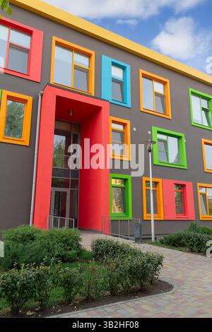 La facciata dell'edificio multicolore della scuola moderna Foto Stock